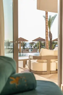 a living room with a view of a patio at Pegasos Deluxe Beach Hotel in Faliraki