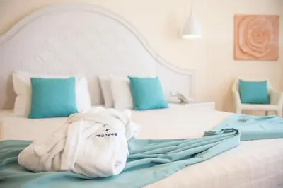 a bedroom with a bed with a towel on it at Pegasos Deluxe Beach Hotel in Faliraki