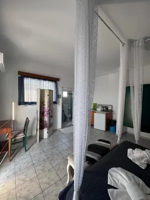 a bedroom with two beds and a table and a desk at SunnySun Studios in Faliraki