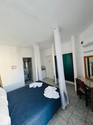 a bedroom with a blue bed with towels on it at SunnySun Studios in Faliraki