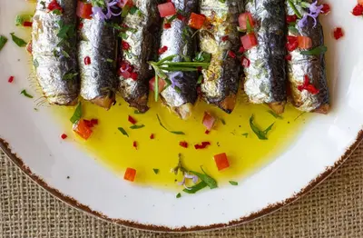 a plate of fish with sauce and vegetables on it at Tsambikos Apts in Faliraki