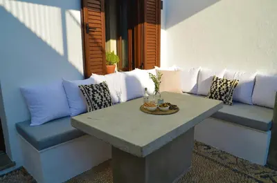 a couch and a table with pillows on a patio at Lindos Aktaia Villa in Líndos
