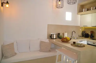 a living room with a white couch in a kitchen at Lindos Aktaia Villa in Líndos