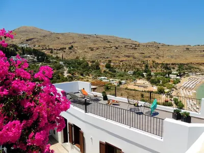 a view from the balcony of a house with pink flowers at Lindos Aktaia Villa in Líndos