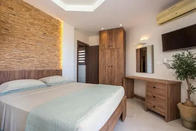 a bedroom with a bed and a brick wall at Casa Lyristis in Faliraki