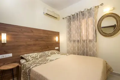 a bedroom with a bed and a mirror on the wall at Casa Lyristis in Faliraki