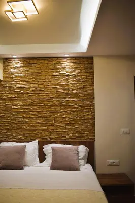 a bedroom with a brick wall and a bed at Casa Lyristis in Faliraki
