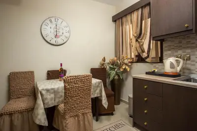 a kitchen with a table and a clock on the wall at Casa Lyristis in Faliraki