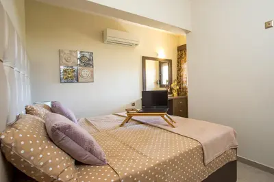 a bedroom with a bed with a laptop on it at Casa Lyristis in Faliraki