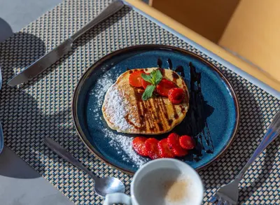 a blue plate with toast and strawberries on a table at Kolymbia Bay Art Boutique Hotel - Adults Only in Kolimbia