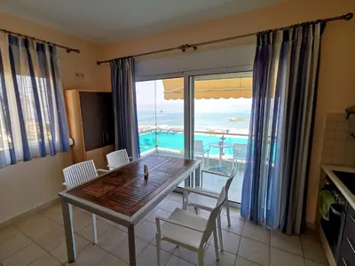 a dining room with a table and a view of the ocean at Tsampika's Sea View Home in Archangelos