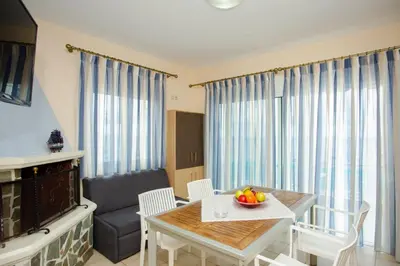 a living room with a table and a couch at Tsampika's Sea View Home in Archangelos