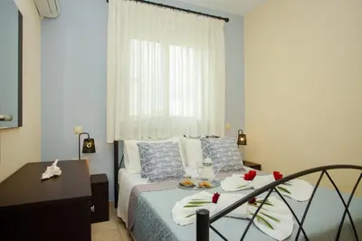 a bedroom with a bed with a table and a window at Tsampika's Sea View Home in Archangelos