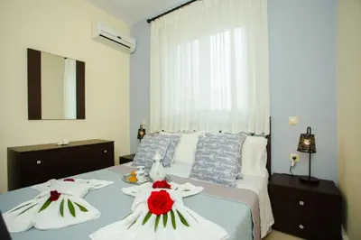 a bedroom with a bed with two dresses on it at Tsampika's Sea View Home in Archangelos