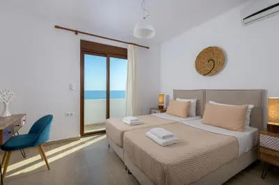 a bedroom with a bed and a desk and a window at Villa Corinna in Lachania