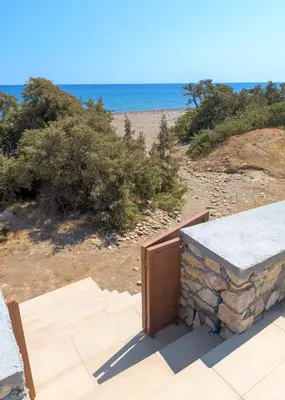 a building with a door on the beach at Villa Corinna in Lachania