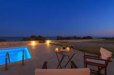 a patio with a table and chairs next to a swimming pool at Villa Corinna in Lachania