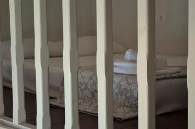 a room with a crib with a table and towels at House Galini in Halki