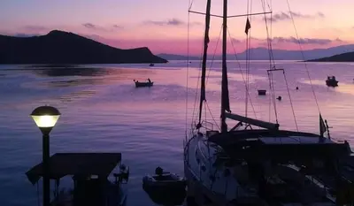 a boat is docked in the water at dusk at House Galini in Halki