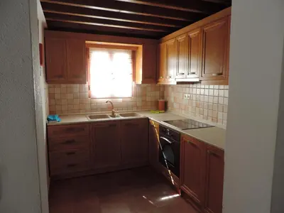 a kitchen with wooden cabinets and a sink and a window at Villa Anna Maria Lindos in Líndos