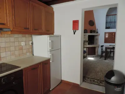 a kitchen with a white refrigerator and a dining room at Villa Anna Maria Lindos in Líndos
