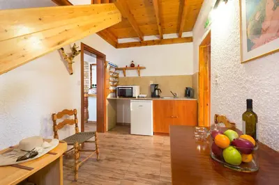 a kitchen and dining room with a table with a bowl of fruit at Elefteria Apts & Suites in Kolimbia