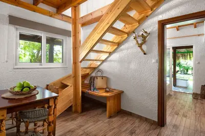 a room with a wooden staircase and a table at Elefteria Apts & Suites in Kolimbia