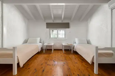 a white room with two beds and a window at Elefteria Apts & Suites in Kolimbia