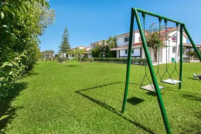 an empty swing set in a yard at Elefteria Apts & Suites in Kolimbia