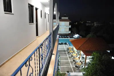 a balcony of a building with a swimming pool at night at Maritime in Kremasti