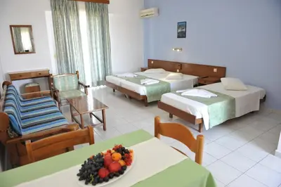 a hotel room with two beds and a table with a bowl of fruit at Maritime in Kremasti