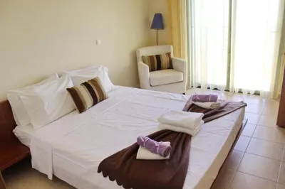 a bedroom with a large white bed with towels on it at Athina in Kiotari