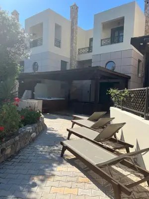 a row of chaise lounges in front of a building at Athina in Kiotari