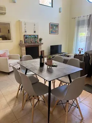 a dining table and chairs in a living room at Athina in Kiotari