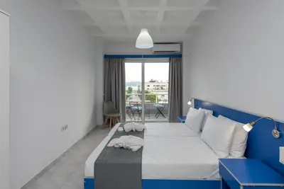 a bedroom with a blue and white bed and a window at MV83 new marina in Rhodes Town