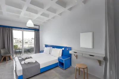 a blue and white bedroom with a bed and a tv at MV83 new marina in Rhodes Town