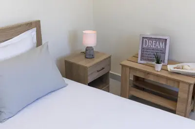 a bedroom with a bed and a lamp on a night stand at Sweet Home Kremasti in Kremasti