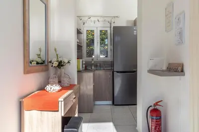 a kitchen with a refrigerator and a counter with a table at Sweet Home Kremasti in Kremasti