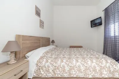 a bedroom with a bed and a lamp and a window at Sweet Home Kremasti in Kremasti