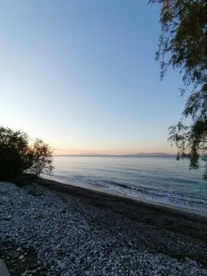a rocky beach with the ocean in the background at Sweet Home Kremasti in Kremasti