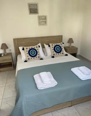 a bedroom with a large bed with two towels at Sweet Home Kremasti in Kremasti