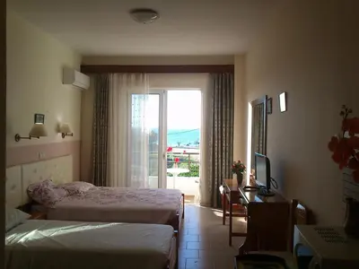 a bedroom with two beds and a desk and a window at Kitesurf Paradise Studios in Theologos