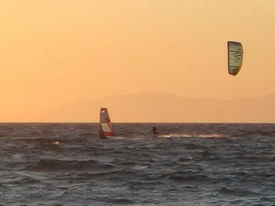 two people are windsurfing in the ocean at Kitesurf Paradise Studios in Theologos