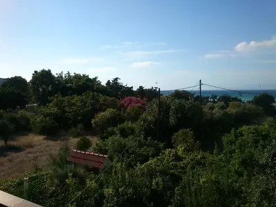 a bench sitting on a hill with a suspension bridge in the background at Kitesurf Paradise Studios in Theologos