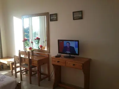 a living room with a television on a wooden table at Kitesurf Paradise Studios in Theologos