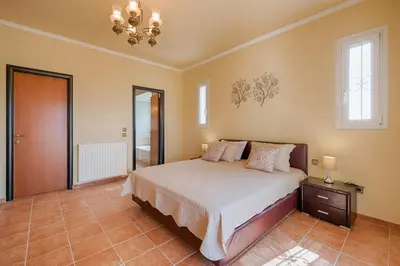 a bedroom with a large bed and a mirror at Royal Classico Villa in Kolimbia