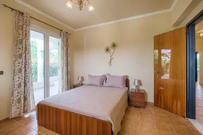 a bedroom with a bed and a large window at Royal Classico Villa in Kolimbia