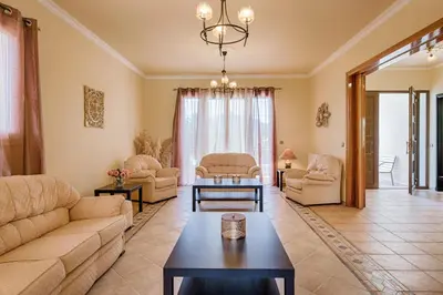 a living room with a couch and a table at Royal Classico Villa in Kolimbia