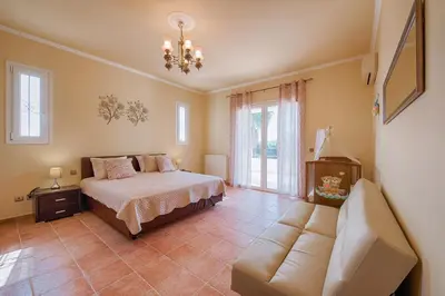 a bedroom with a bed and a couch at Royal Classico Villa in Kolimbia