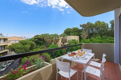 a balcony with a table and chairs and a view at Melita City Apartment in Rhodes Town